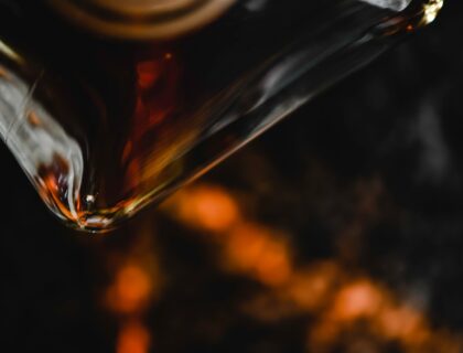 Whiskyglas und Flasche in gedecktem Licht